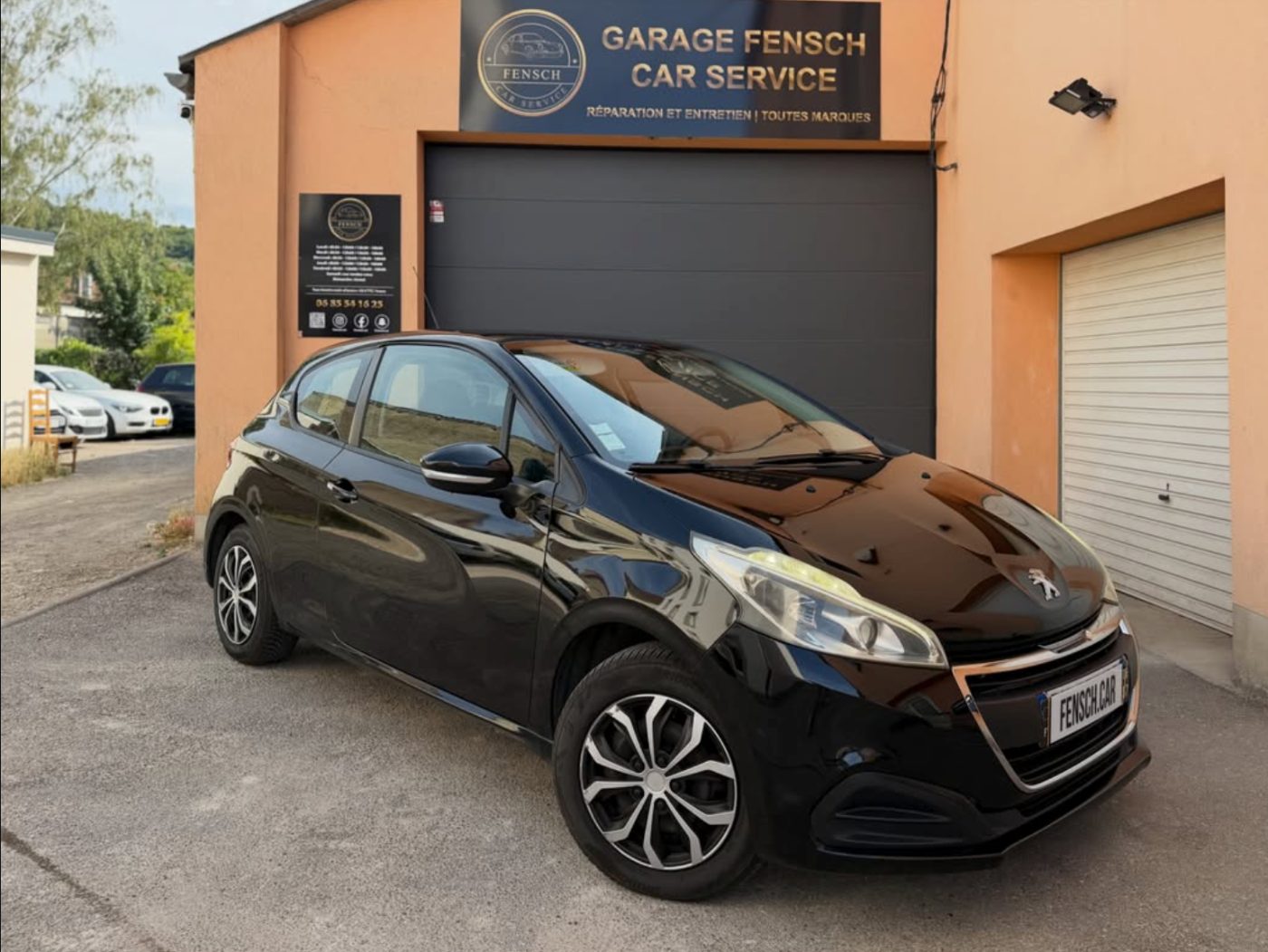 Peugeot 208 noire d'occasion devant le garage Fensch Car Service à Nilvange